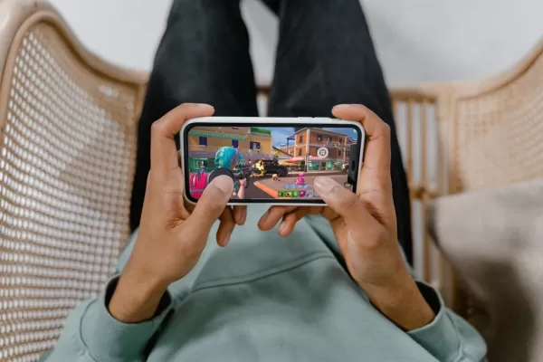 gamer holding phone with magnetic trigger attachment playing Fortnite